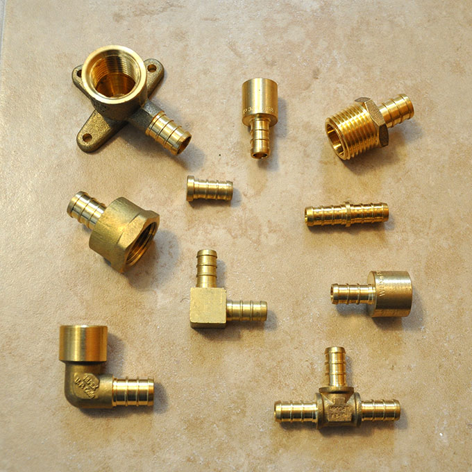 PEX-AL-PEX multilayer plumbing pipes with metal fittings showing modern water supply system technology used in residential plumbing.